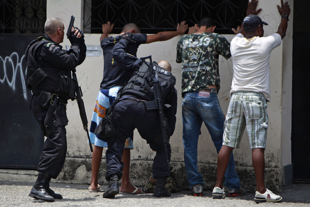 ap foto : felipe dana : police officers frisk suspects during an operation at the vila cruzeiro slum in rio de janeiro, brazil, thursday, nov. 25, 2010. police raided gang-ruled shantytowns and said a number of suspected criminals died in gunbattles on wednesday as authorities tried to halt a wave of violence that has rattled rich and poor alike in the brazilian city. (ap photo/felipe dana) brazil rio violenc automatarkiverad
