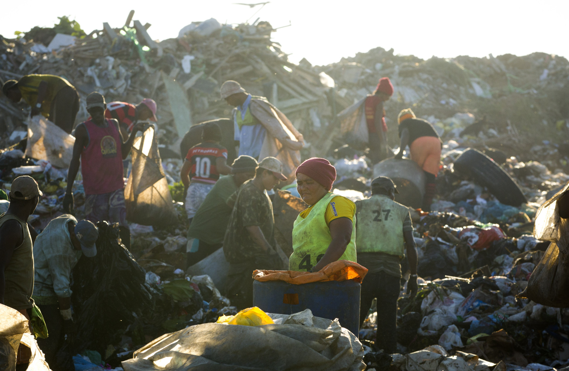 In this May 29, 2012 photo, people collect recyclable materials at Jardim Gramacho, one of the world's largest open-air landfills, in Rio de Janeiro, Brazil. Jardim Gramacho, a vast, seaside mountain of trash where thousands of people made a living sorting through the debris by hand, is closing after three decades in service. (AP Photo/Victor R. Caivano)